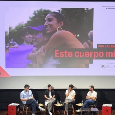 Los protagonistas de la película "Este cuerpo mío" en un pase en el cine, con el póster de la película detrás.