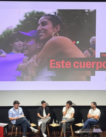 Los protagonistas de la película "Este cuerpo mío" en un pase en el cine, con el póster de la película detrás.